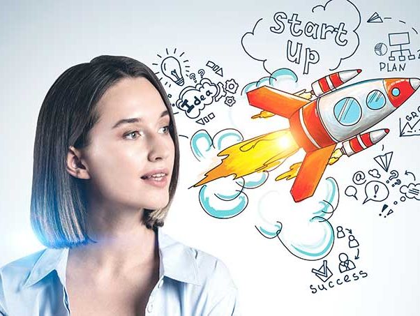 Woman looking right to a graphic of a spaceship with words such as 'start up', 'idea' and 'success' drawn around it.