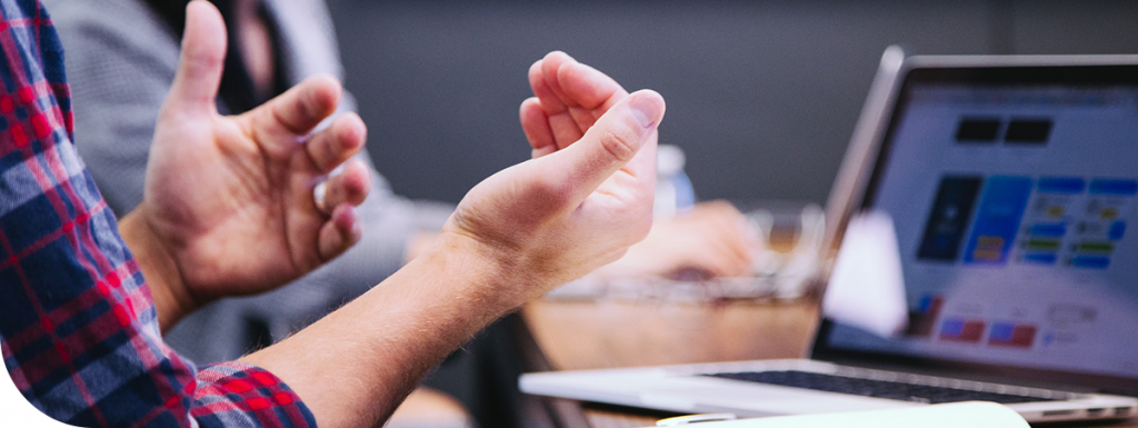 Stock image of hands held up in front of computer screen