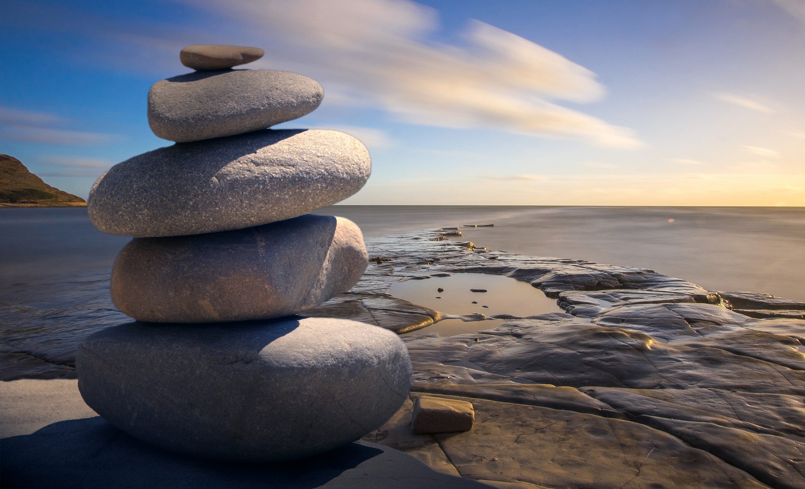 Stock image of rocks stacked on a beach, representing the risks nearby for all constructions