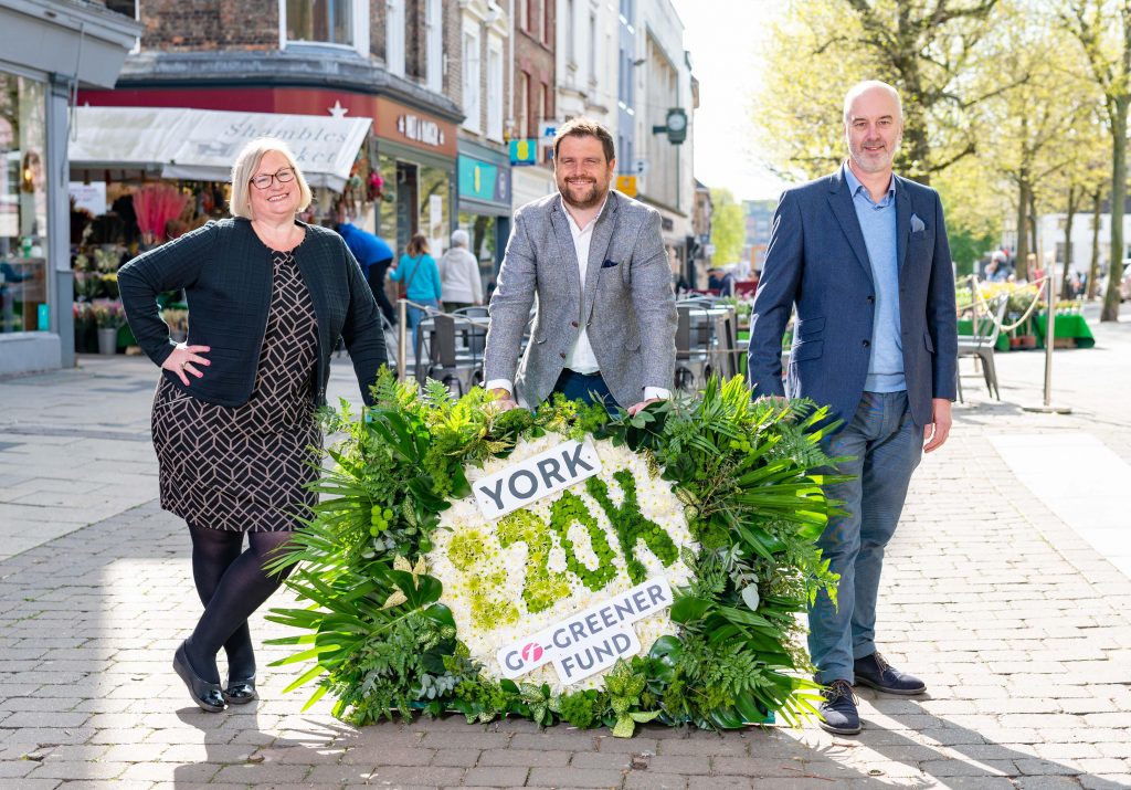 Representatives from First York, the Federation of Small Businesses and York & North Yorkshire Local Enterprise Partnership pose by a York Go Greener floral arrangement on Parliament Street in York